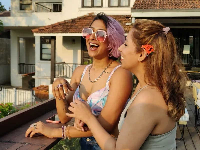 Two friends laughing on a balcony