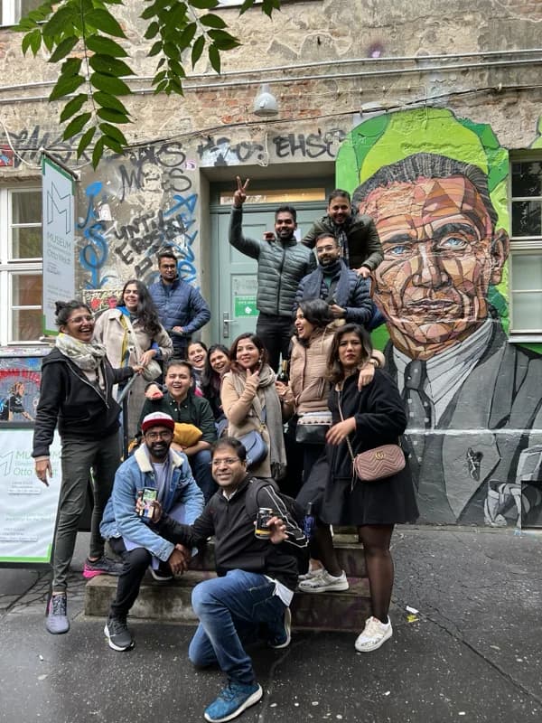 A group gathered in front of a street mural