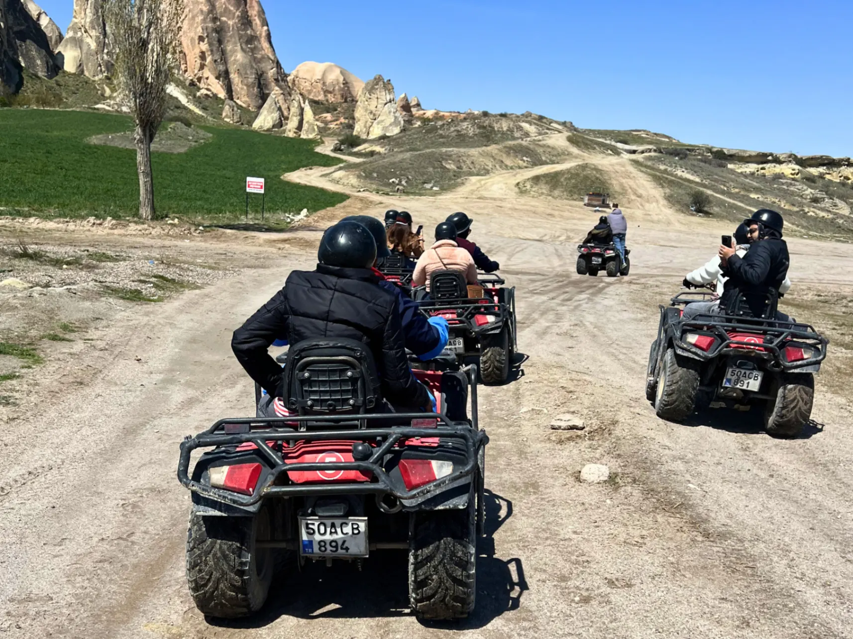 Golden-hour quad ride through the fairy-chimney valleys, dust rising, the landscape turning copper