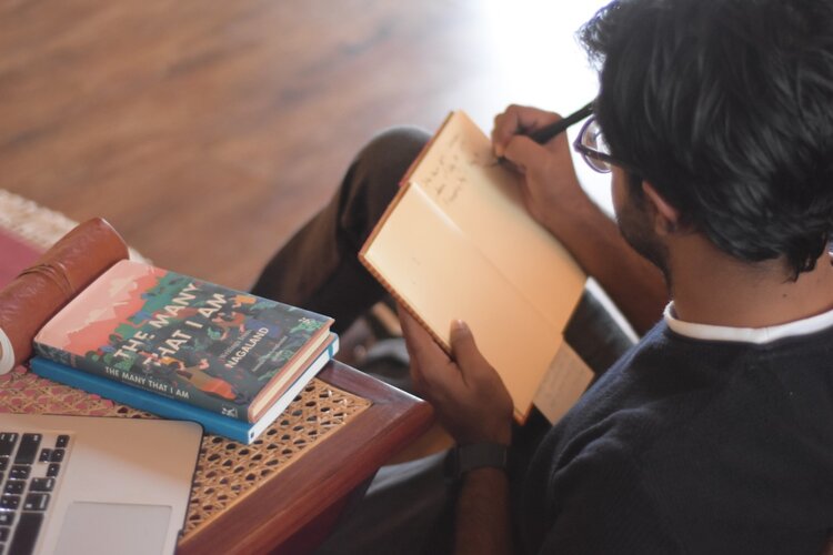 An ExCo traveler writing in a notebook